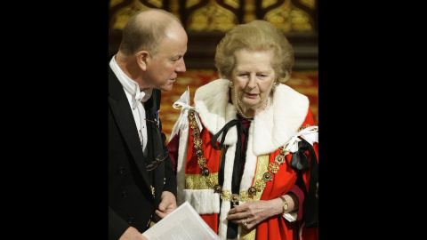 An usher helps Thatcher, now a baroness, to her seat during the state opening of Parliament in November 2009.