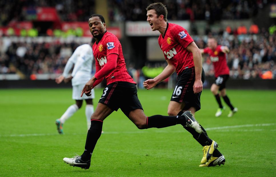 Evra races away to celebrate with teammate Michael Carrick in hot pursuit as the league leaders make the perfect start in Wales.