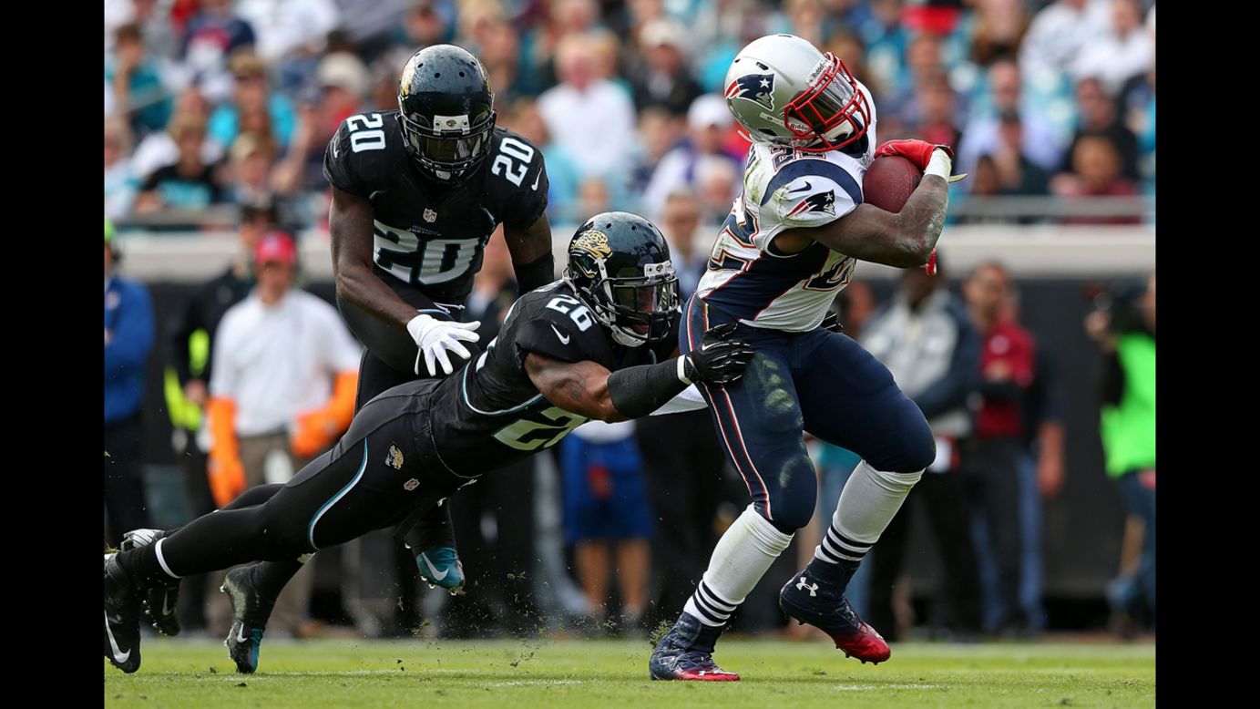Stevan Ridley of the Patriots is tackled by Dawan Landry of the Jaguars on Sunday.