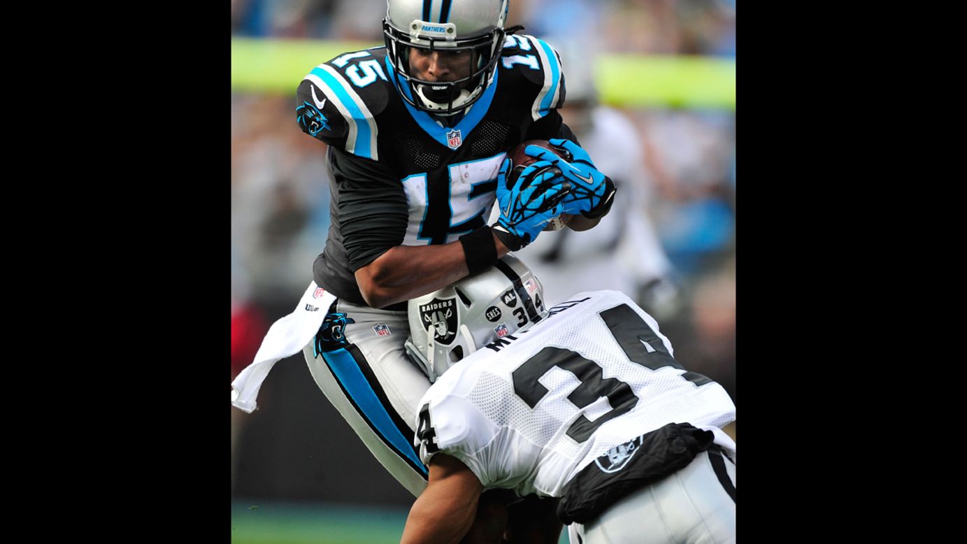 Joe Adams of the Panthers makes a catch as Mike Mitchell of the Raiders defends on Sunday.