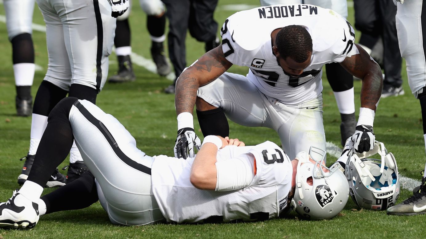 Darren McFadden of the Raiders checks on quarterback Carson Palmer after Palmer was knocked down in the first half against the Panthers on Sunday.