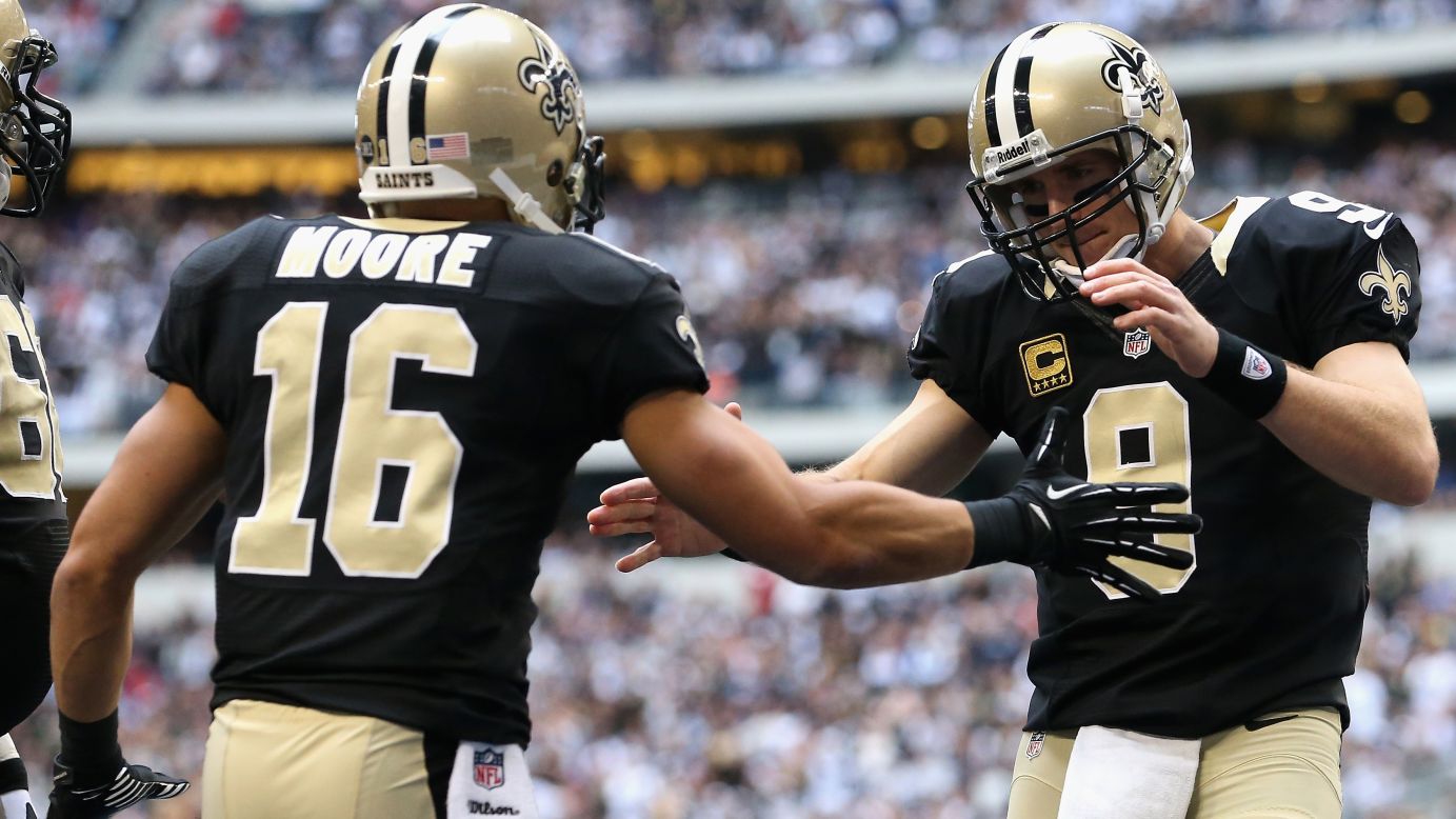 Drew Brees of the Saints celebrates a touchdown with Lance Moore against the Cowboys on Sunday.