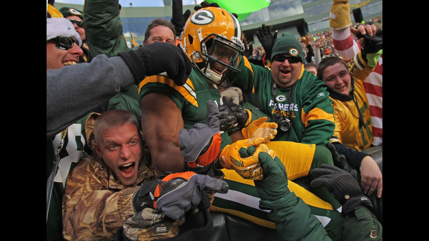 Randall Cobb of the Packers leaps into the stands after scoring a touchdown against the Titans on Sunday.