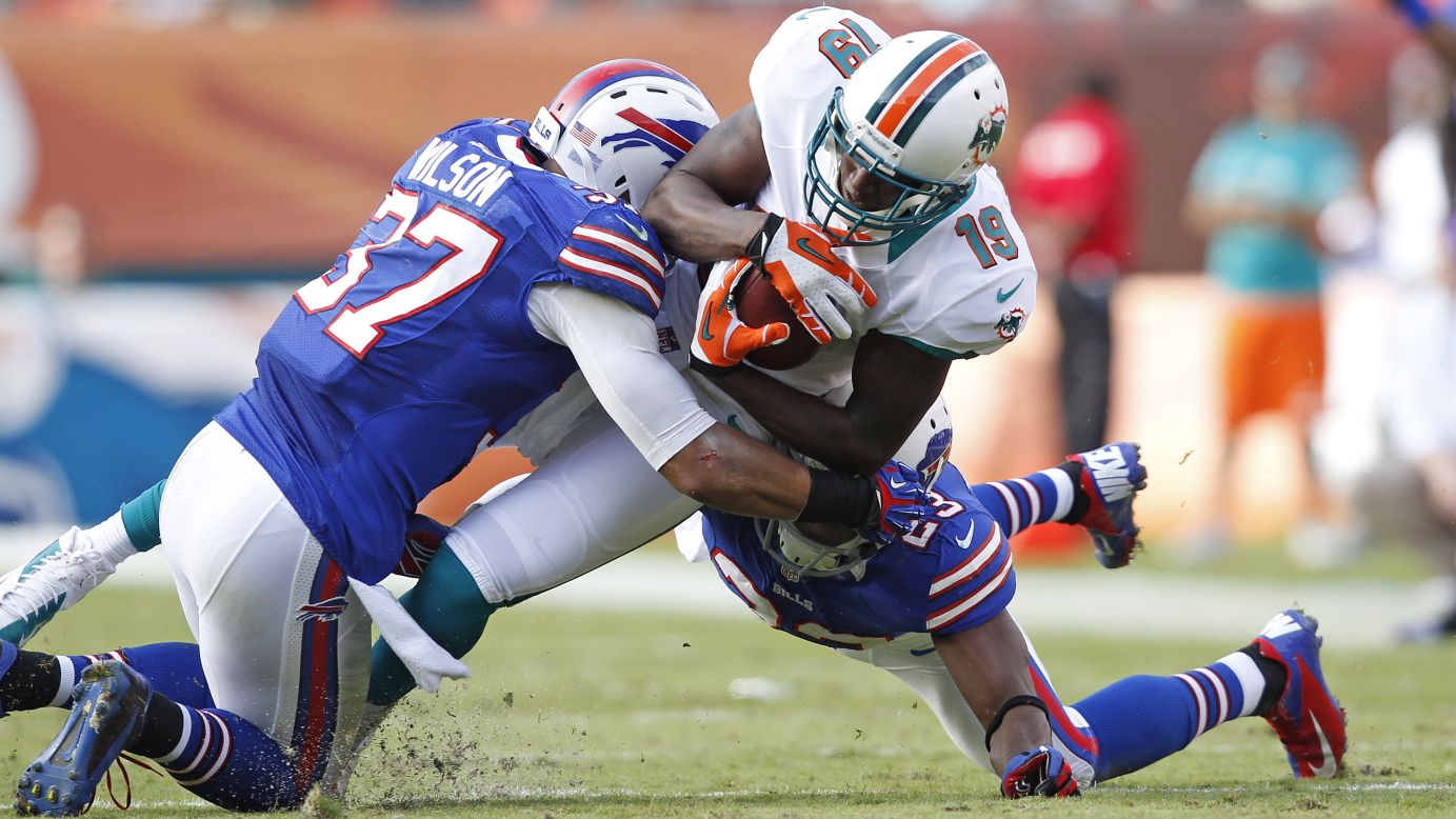 Armon Binns of the Miami Dolphins is tackled by Aaron Williams and George Wilson of the Buffalo Bills as he runs with the ball on Sunday at Sun Life Stadium in Miami Gardens, Florida. The Dolphins defeated the Bills 24-10.