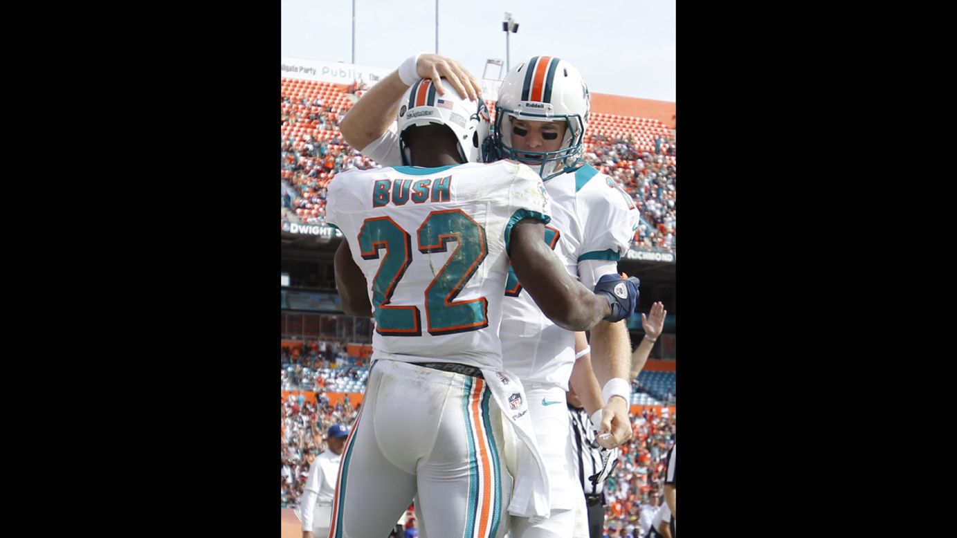 Ryan Tannehill congratulates Reggie Bush of the Dolphins after he scored his first touchdown of the game against the Bills on Sunday.