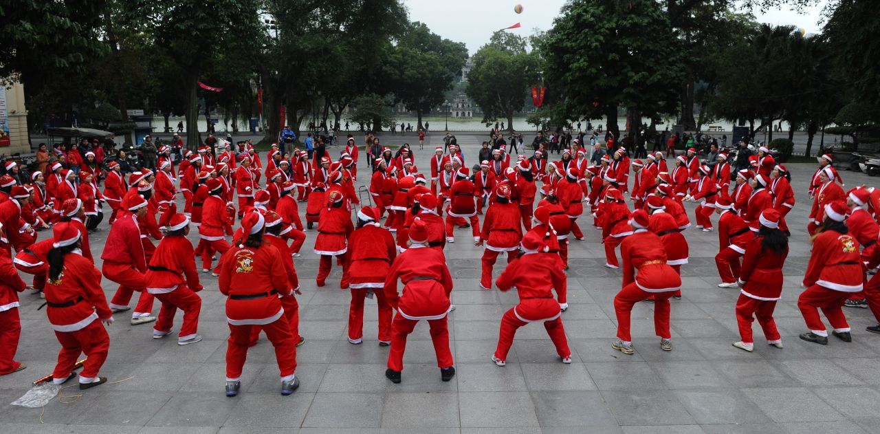 Members of a local yoga club perform at a public park wearing Santa Claus costumes in Hanoi, Vietnam, on December 23. 