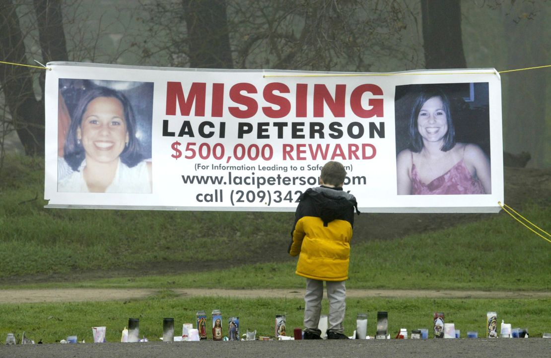 A young child stops to look at a memorial and a banner offering a half-million dollar reward for the safe return of Laci Peterson at the East La Loma Park  in Modesto, California, on January 4, 2003. 