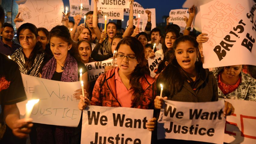Indian youth hold candles and placards as they take part in a candle light vigil following the gang rape of a student last week in the Indian capital during a rally in Ahmedabad on December 23, 2012.