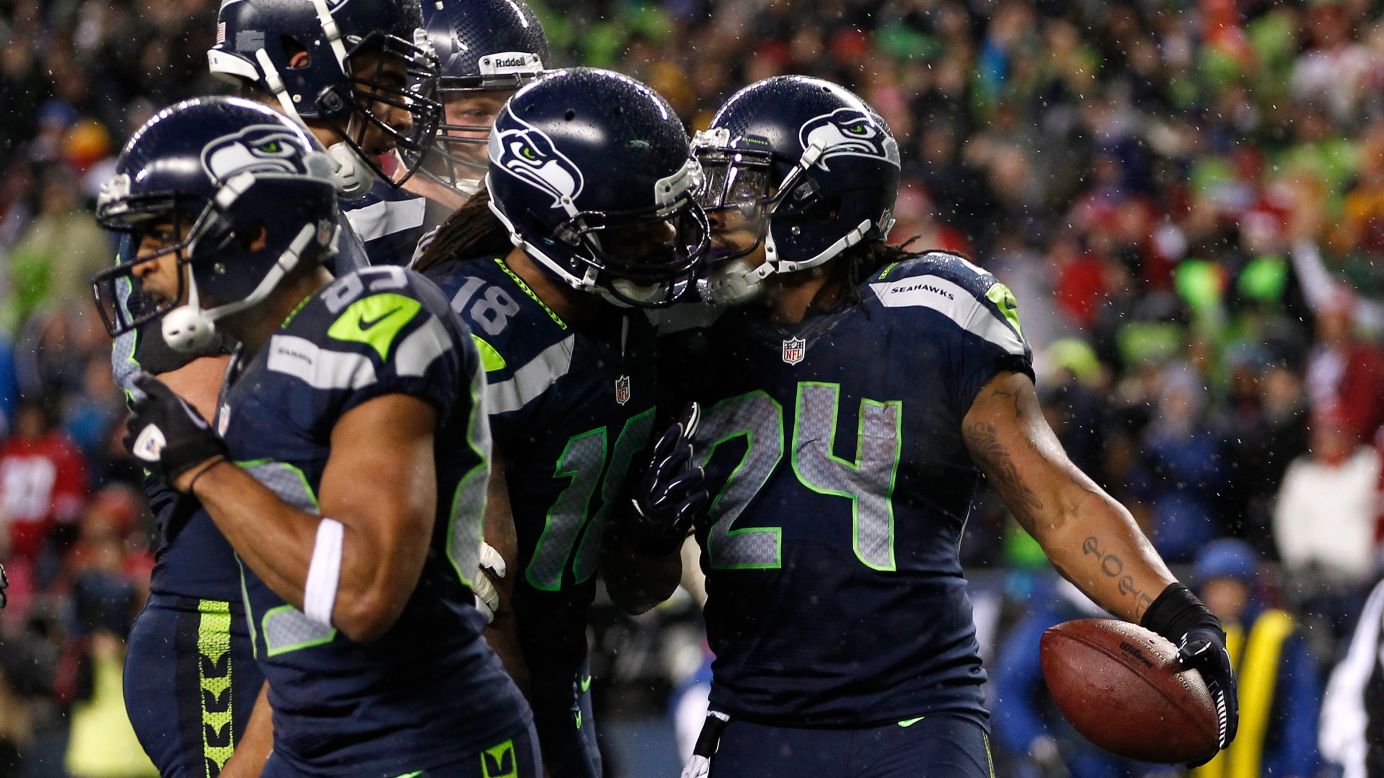 Marshawn Lynch, right, of the Seattle Seahawks celebrates with teammates after scoring a nine-yard touchdown catch on Sunday.