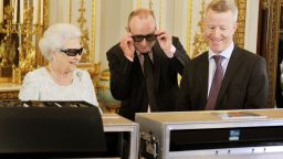Queen Elizabeth II watches the recording of her Christmas message with producer John McAndrew and director John Bennett (R). The speech will be broadcast to the Commonwealth in 3D for the first time in the White Drawing Room of Buckingham Palace. 