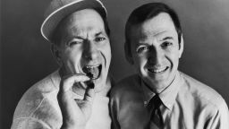 circa 1970: American actors Jack Klugman (L), holding a cigar, and Tony Randall, holding a plate of finger sandwiches, pose in a promotional portrait for the television comedy series, 'The Odd Couple'. (Photo by Hulton Archive/Getty Images) 