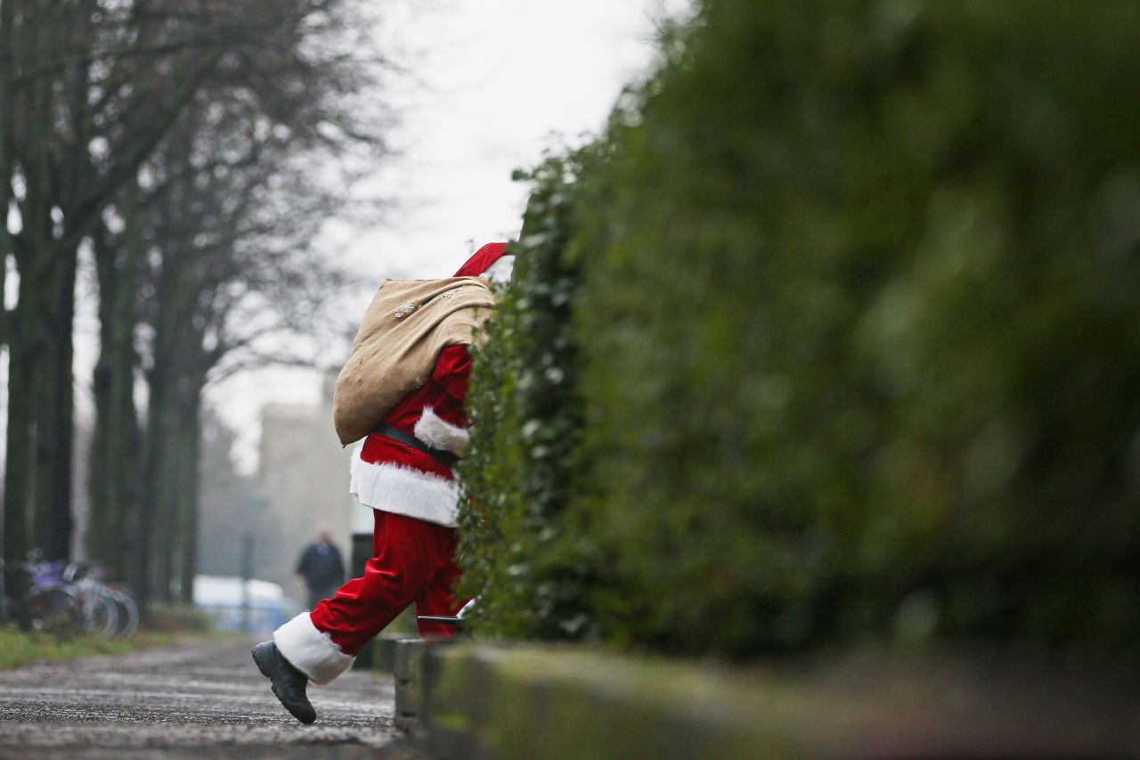 A man decked out as Santa Claus slips through the back streets of Hamburg, Germany, on Monday, December 24. <a href="http://cnnphotos.blogs.cnn.com/2012/12/22/magnum-santas/">Related photos: Magnum Santas</a>