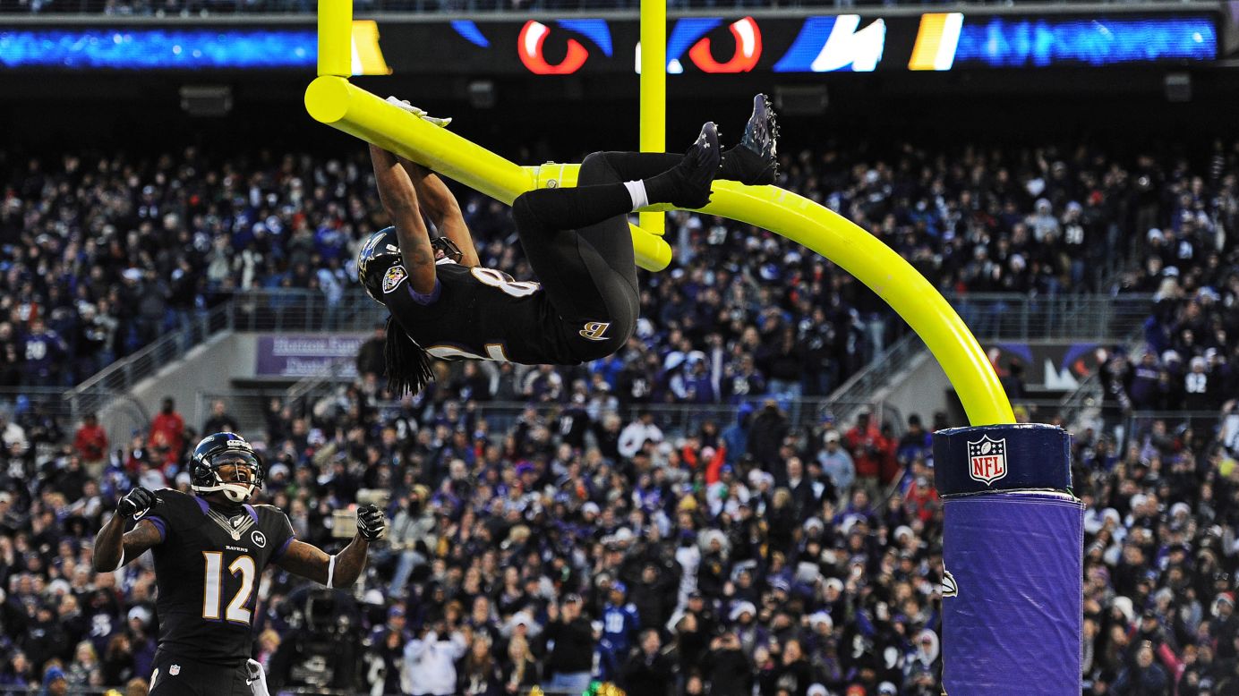 Wide receiver Torrey Smith of the Ravens hangs on the goal post after catching a touchdown pass during the first quarter on Sunday.