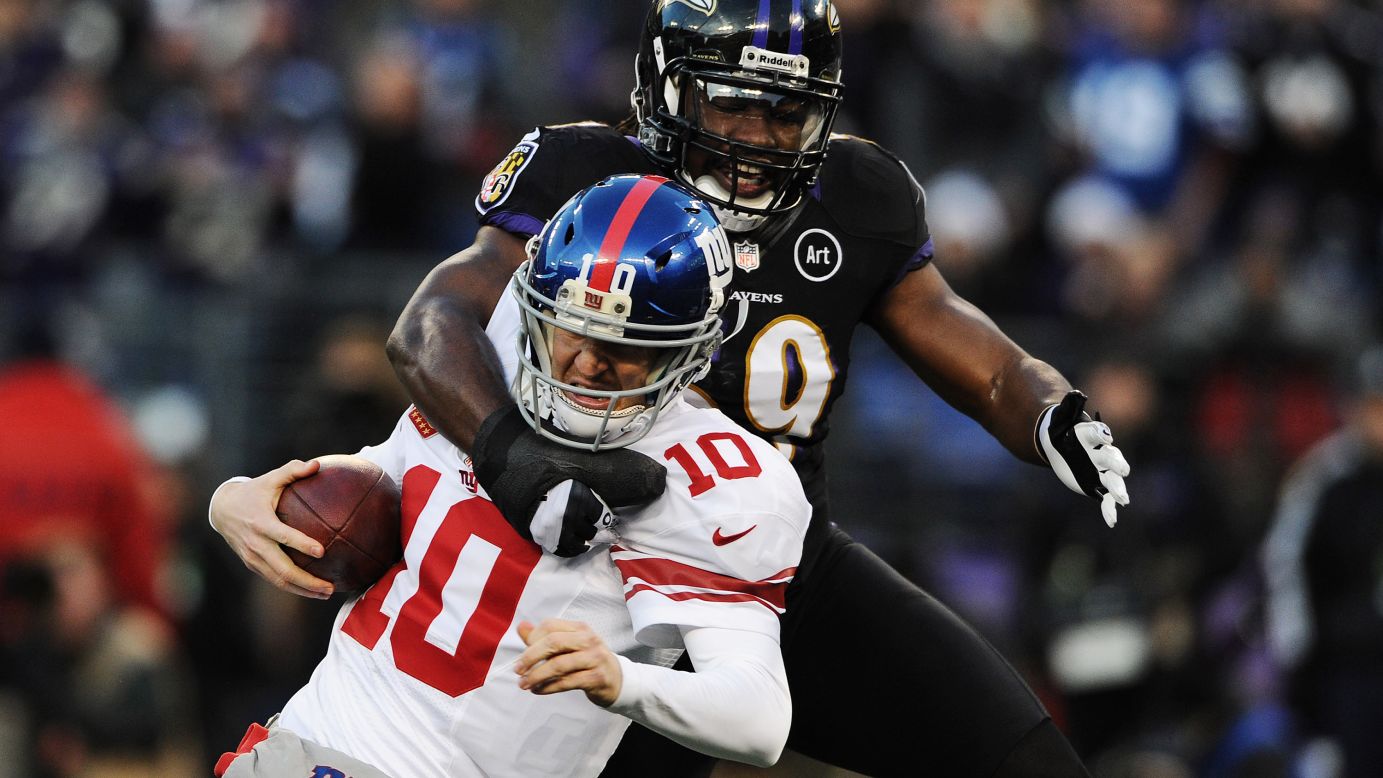 Quarterback Eli Manning of the Giants is pulled down by linebacker Dannell Ellerbe of the Ravens on Sunday.
