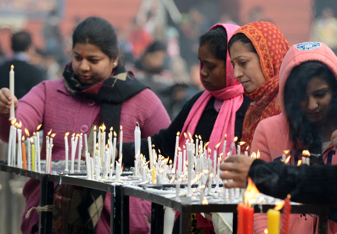 People light candles as they gather to pray during Christmas celebrations at The Sacred Heart Cathedral in New Delhi on Tuesday. 