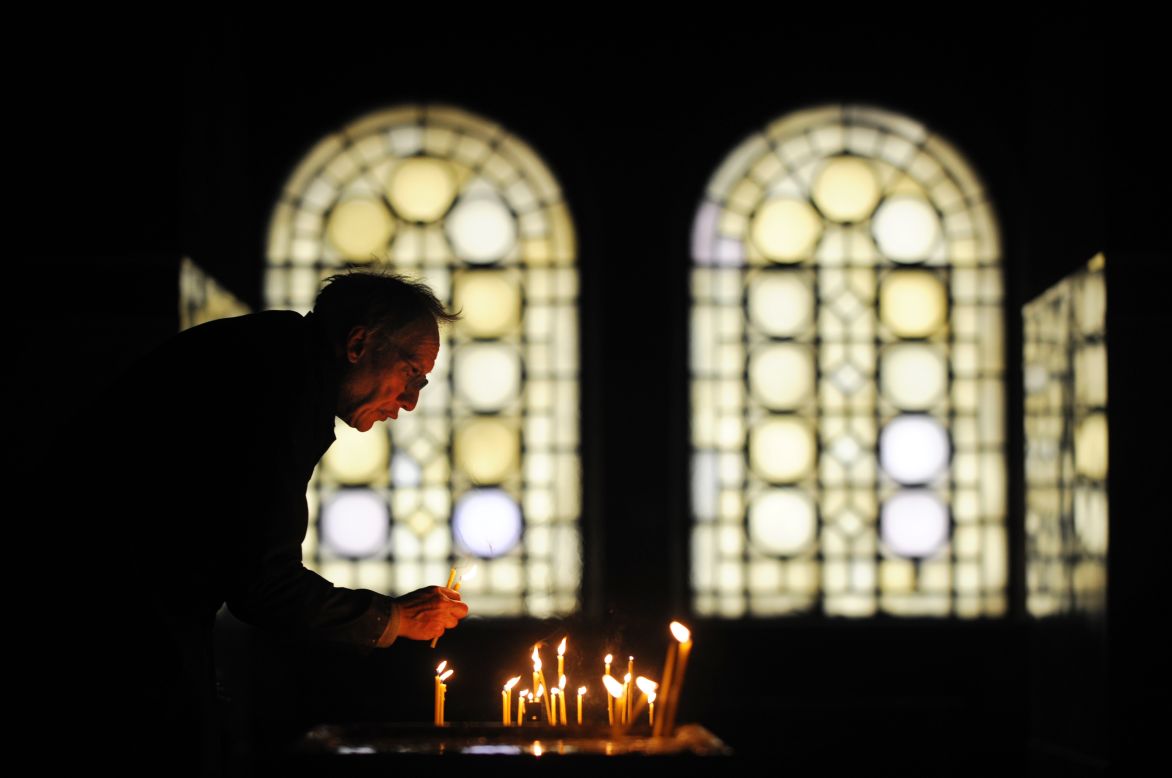 A sexton collects candles during a Christmas Mass in the golden-domed Alexander Nevsky Cathedral in Sofia, Bulgaria.
