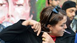 An Egyptian protester cuts her hair during a demonstration mostly by Egyptian women against their country's new constitution draft, on December 25, 2012 in Cairo.