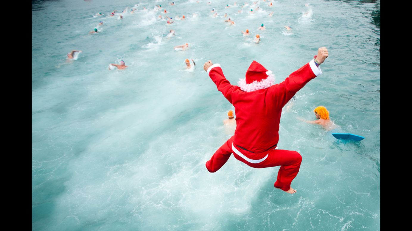 A competitor dressed  as Santa jumps into the water during the 103rd Barcelona Traditional Christmas Swimming Cup at the Old Harbour of Barcelona in Barcelona, Spain, on Tuesday, December 25.