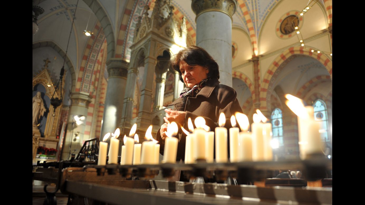 A woman lights candles after a Christmas Mass at Sarajevo's Cathedral of The Heart Of Jesus.