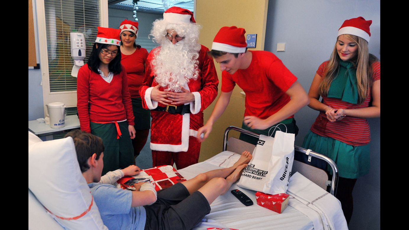 Volunteers of the medical students association Carabins, dressed as Santa Claus, distribute gifts to sick children at the Bordeaux's Hospital for sick children,  in southwestern France. 
