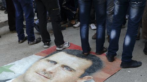 Syrian protesters step on President al-Assad's portrait during an anti-regime demonstration in Aleppo on November 16, 2012. 