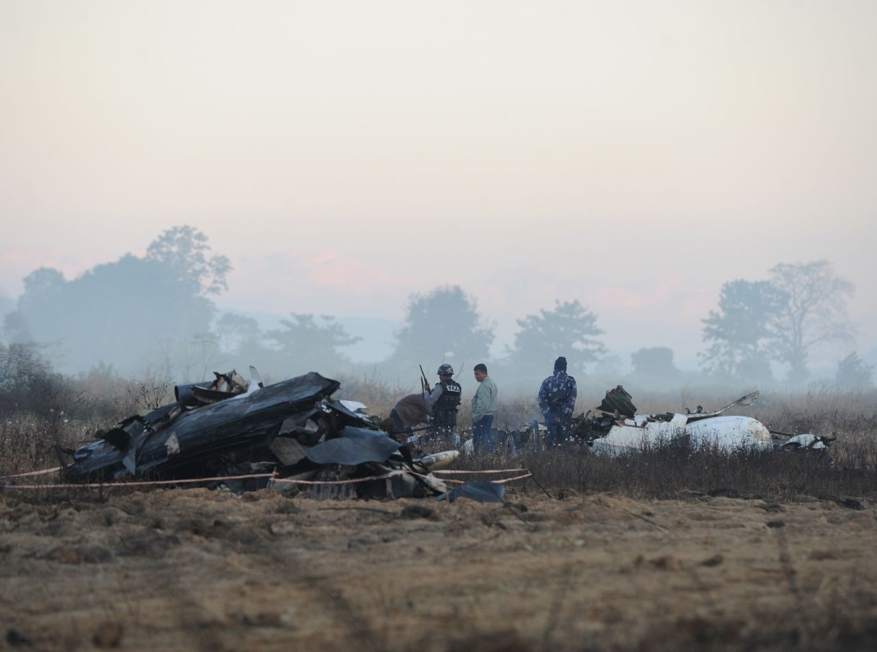 Security officers stand guard at the crash site of a plane near Myanmar's Heho Airport on Wednesday, December 26. The plane crashed near the airport Tuesday, December 25, leaving two people dead and injuring 11others.