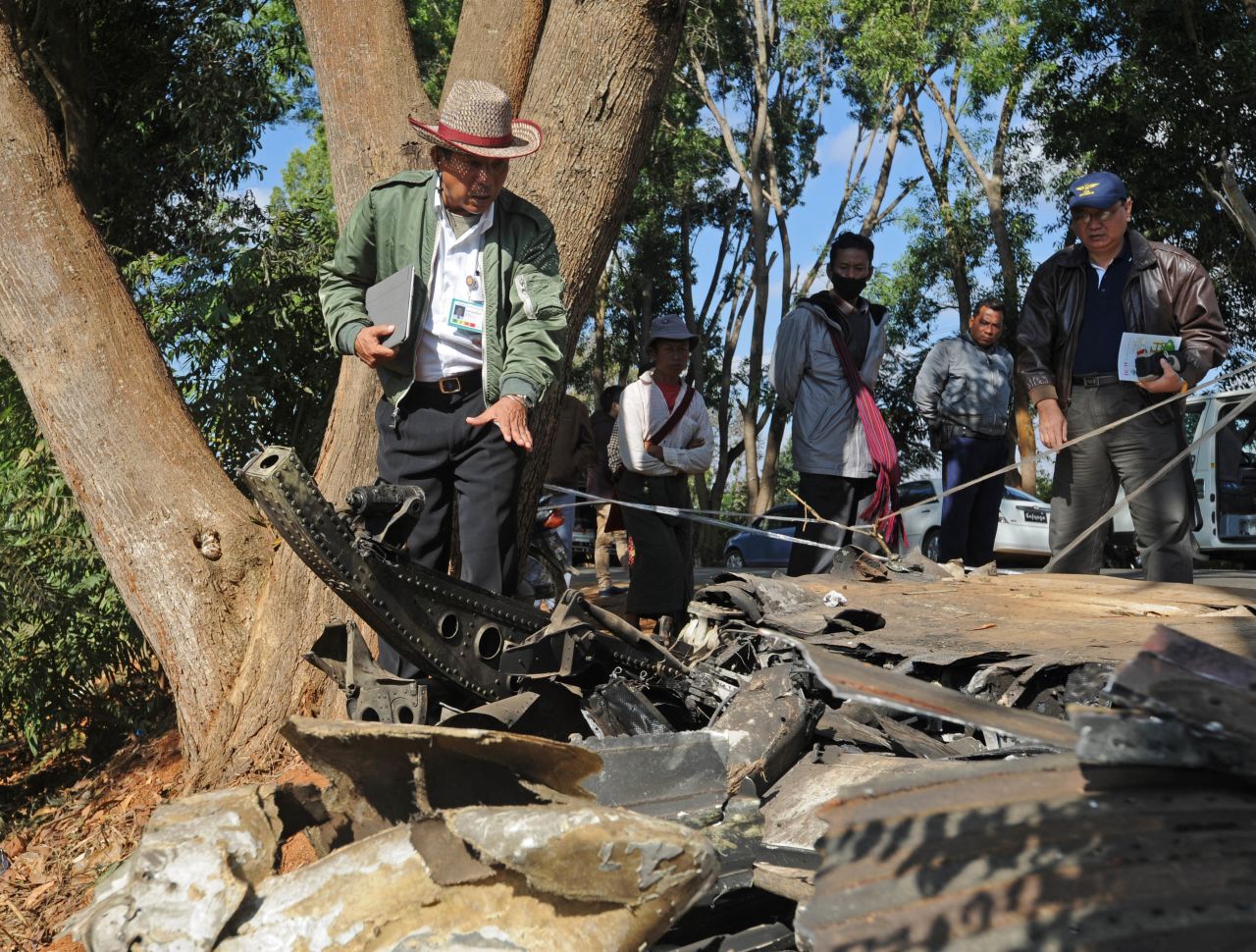 An officer from Myanmar's Department of Civil Aviation inspects the remains of the plane on December 26. An Air Bagan representative said the airline was investigating the crash.