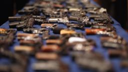 A table of illegal firearms confiscated in a large weapons bust in New York's East Harlem is on display at an October 12 news conference.