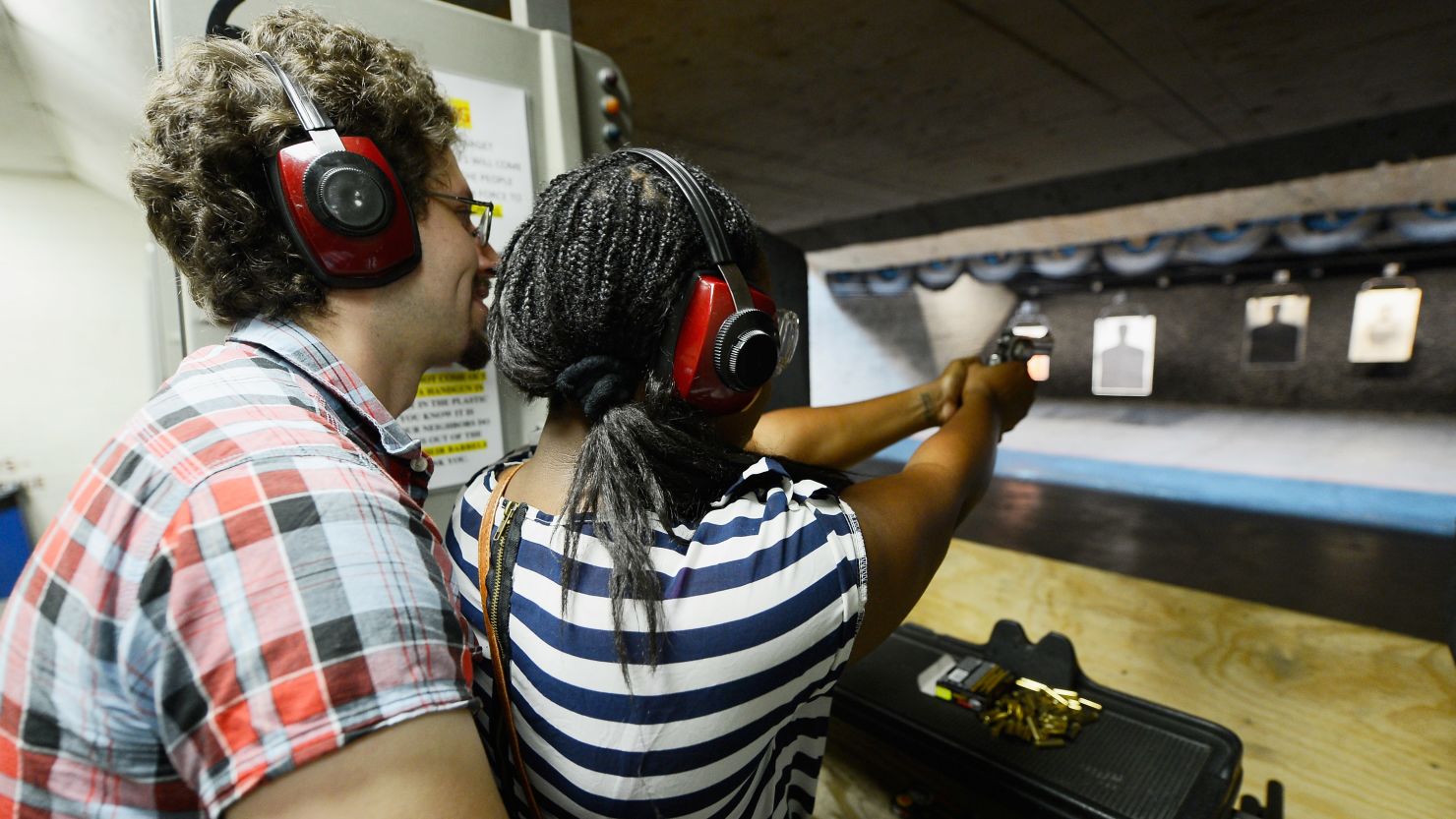 Domenic Lether teaches his girlfriend Ngozi Ogbeni how to shoot a Smith & Wesson .357 magnum revolver at a target range at the Los Angeles Gun Club.