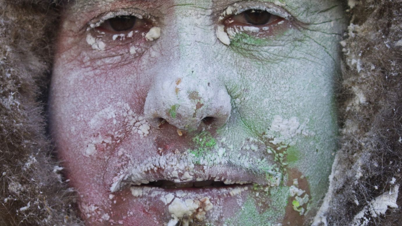 A military-dressed man with flour and eggs on his face poses for a photograph on December 28.