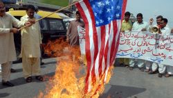 A Pakistani protester belonging to United Citizen Action holds a burning US flag during a protest in Multan on August 19, 2012 against the US drone attacks in Pakistani tribal areas