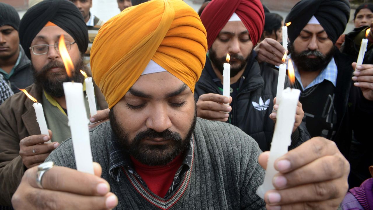 Indian residents hold lighted candles during a rally in Amritsar on December 29.