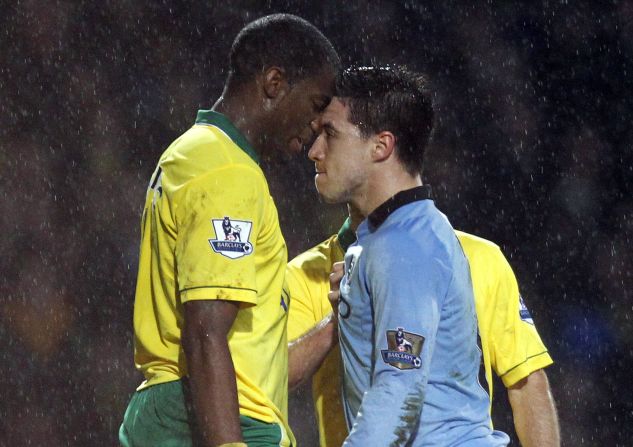 It was pouring down in Norwich, where second-placed Manchester City won 4-3 despite having Samir Nasri (R) sent off following this clash with Sebastien Bassong, who was booked.