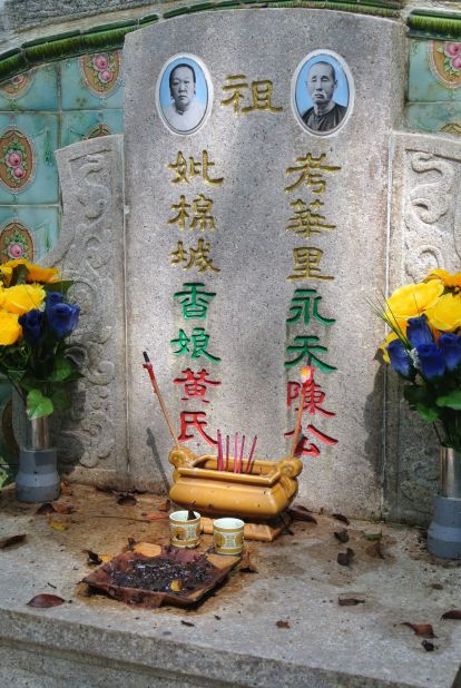 The tomb of Mr. and Mrs. Tan Yong Thian is seen in Bukit Brown cemetery with incense and recent offerings.