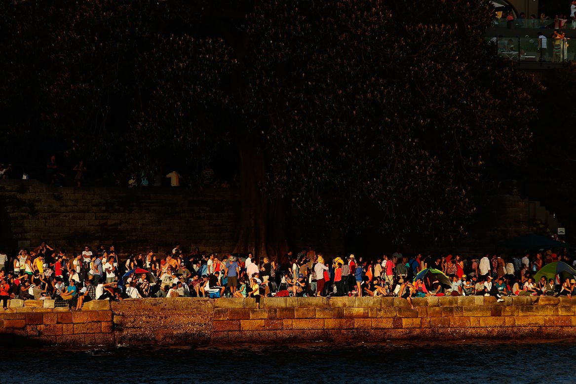 People line the harbour in anticipation of New Year's Eve celebrations in Sydney on Monday, December 31.
