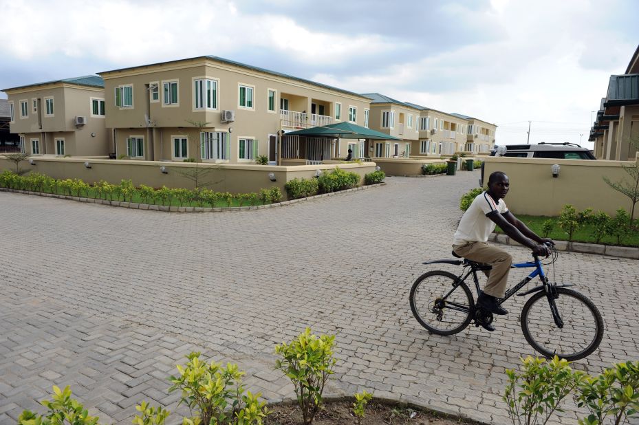 A cyclist rides past dozens of detached three-bedroom apartments in Ogun State, Nigeria on August 30.