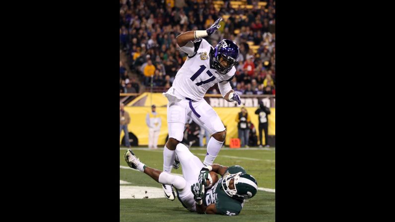 Michigan State's Aaron Burbridge scores a 15-yard touchdown past TCU's Sam Carter during the third quarter of the Buffalo Wild Wings Bowl.