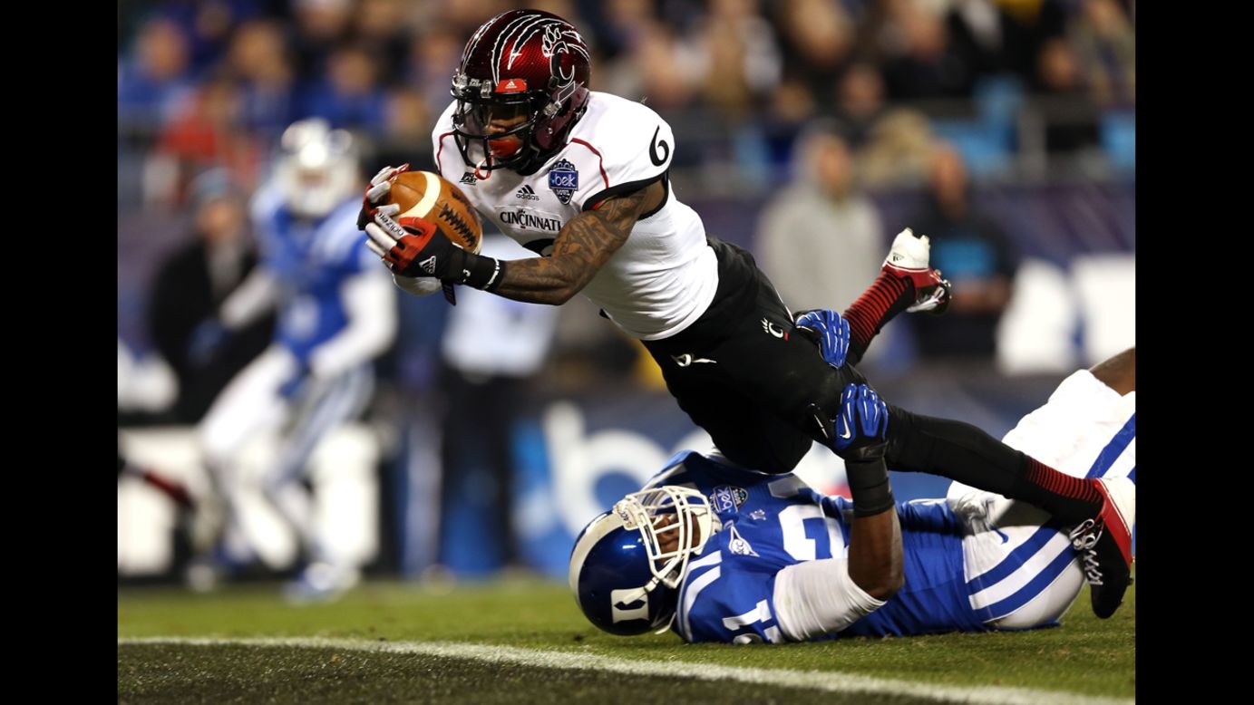 Anthony McClung of the Cincinnati Bearcats dives for a touchdown as Anthony Young-Wiseman of the Duke Blue Devils tries to bring him down on the goal line during the Belk Bowl at Bank of America Stadium on December 27 in Charlotte, North Carolina.  