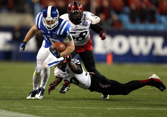 Aaron Roberson of the Cincinnati Bearcats dives for Brandon Connette of the Duke Blue Devils on December 27.