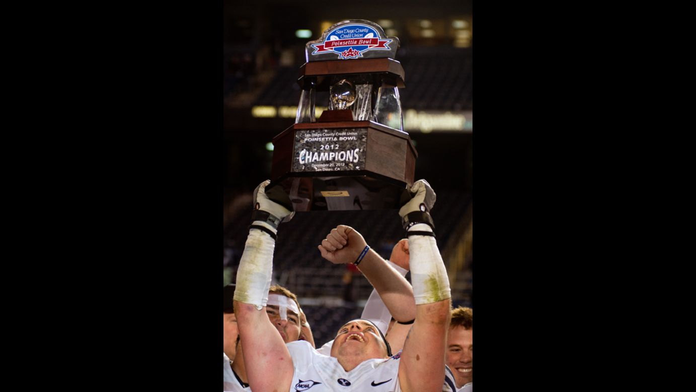 Brandon Ogletree of the BYU Cougars hoists the championship trophy after beating the San Diego State Aztecs 23-6 in the Poinsettia Bowl on December 20.