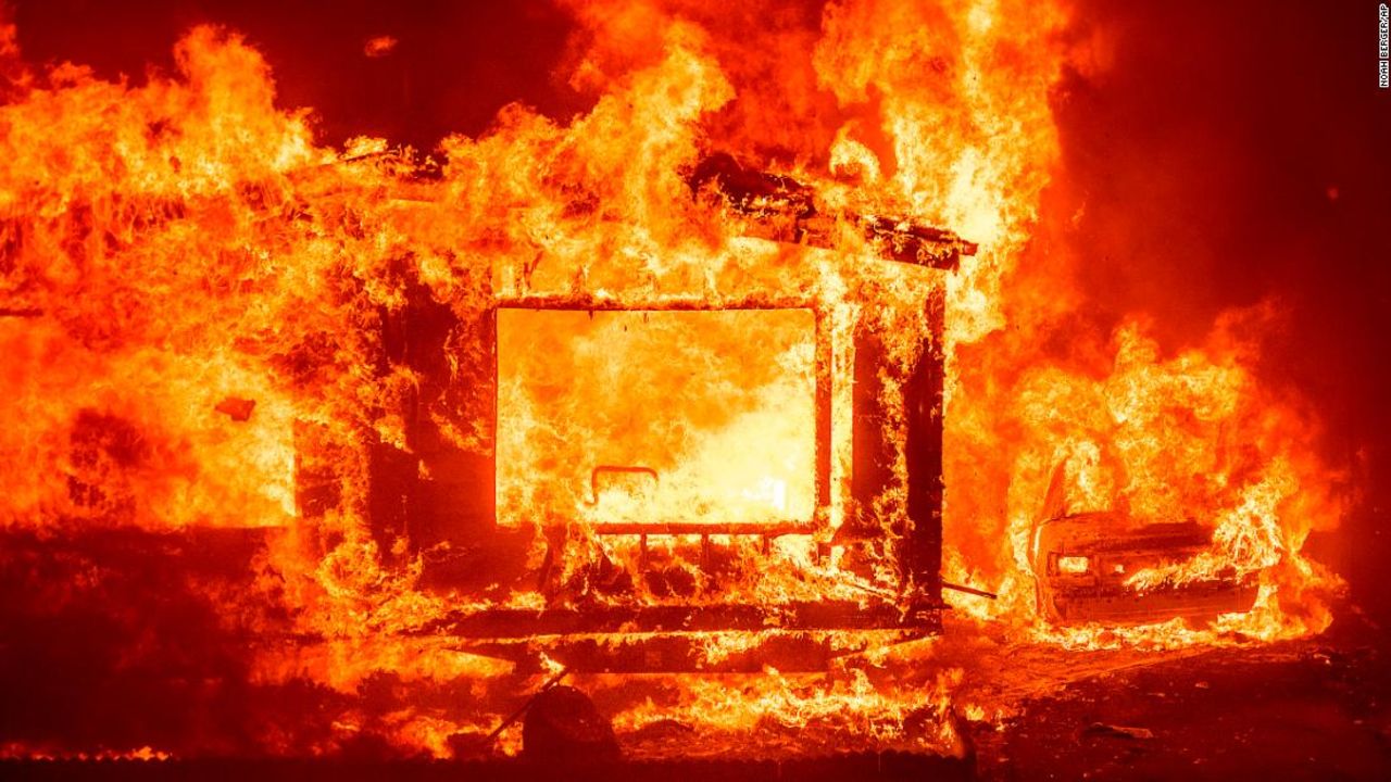 A mobile home and car burn Tuesday at Spanish Flat Mobile Villa as the LNU Complex fires tear through unincorporated Napa County, California.