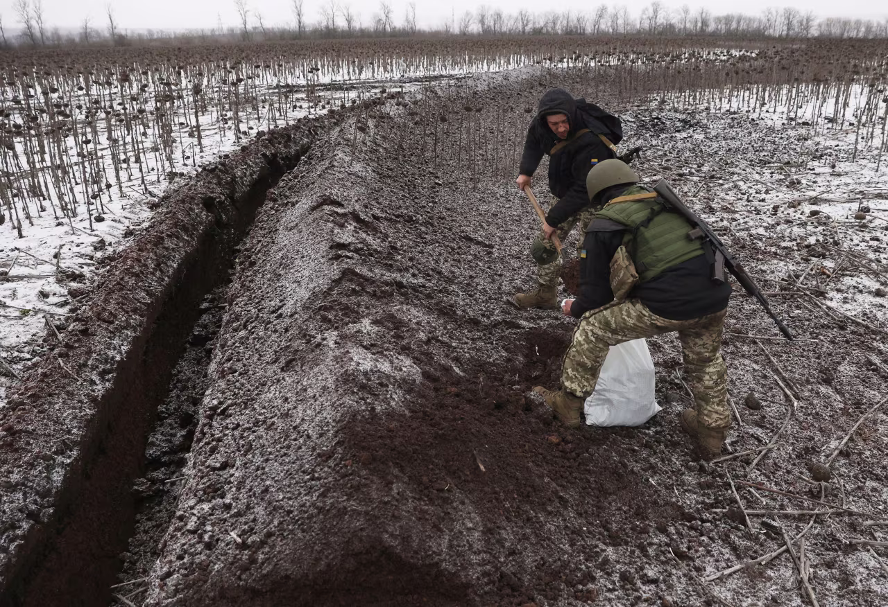 Ukrainian soldiers equip trenches on a field not far from Soledar on Saturday. 