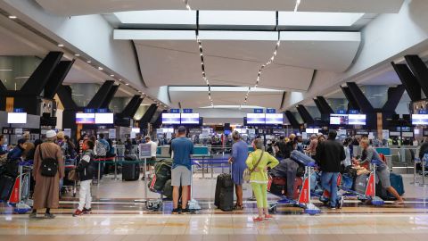Travelers queue at a check-in counter at OR Tambo International Airport in Johannesburg on November 27.