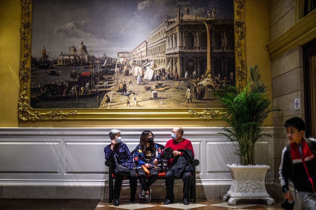 Visitors wear face masks as they sit inside the Venetian casino hotel resort in Macao on Wednesday.