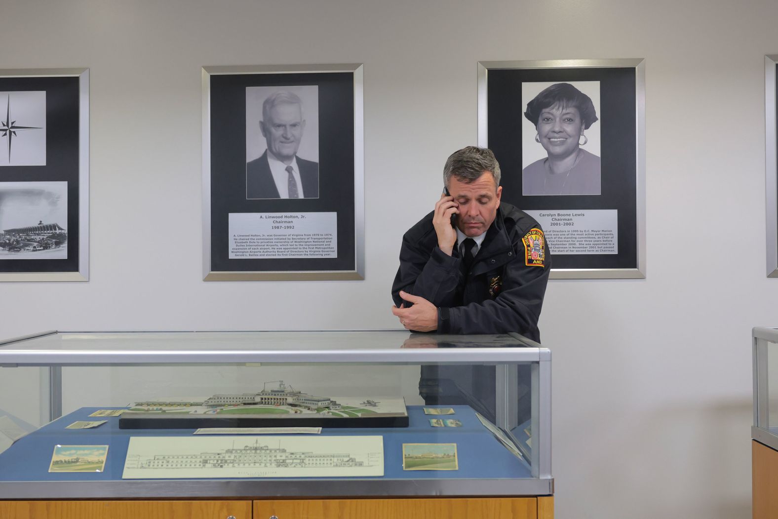 DC Assistant Fire Chief James D. Hanson talks on the phone at Reagan National Airport as emergency crews work on Thursday.