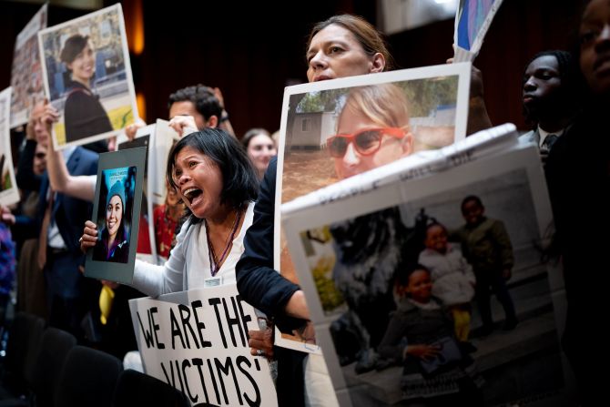 People who lost family members in plane crashes hold up photos of their loved ones as Boeing CEO Dave Calhoun leaves a US Senate hearing in Washington, DC, on Tuesday, June 18. During the hearing, <a href=