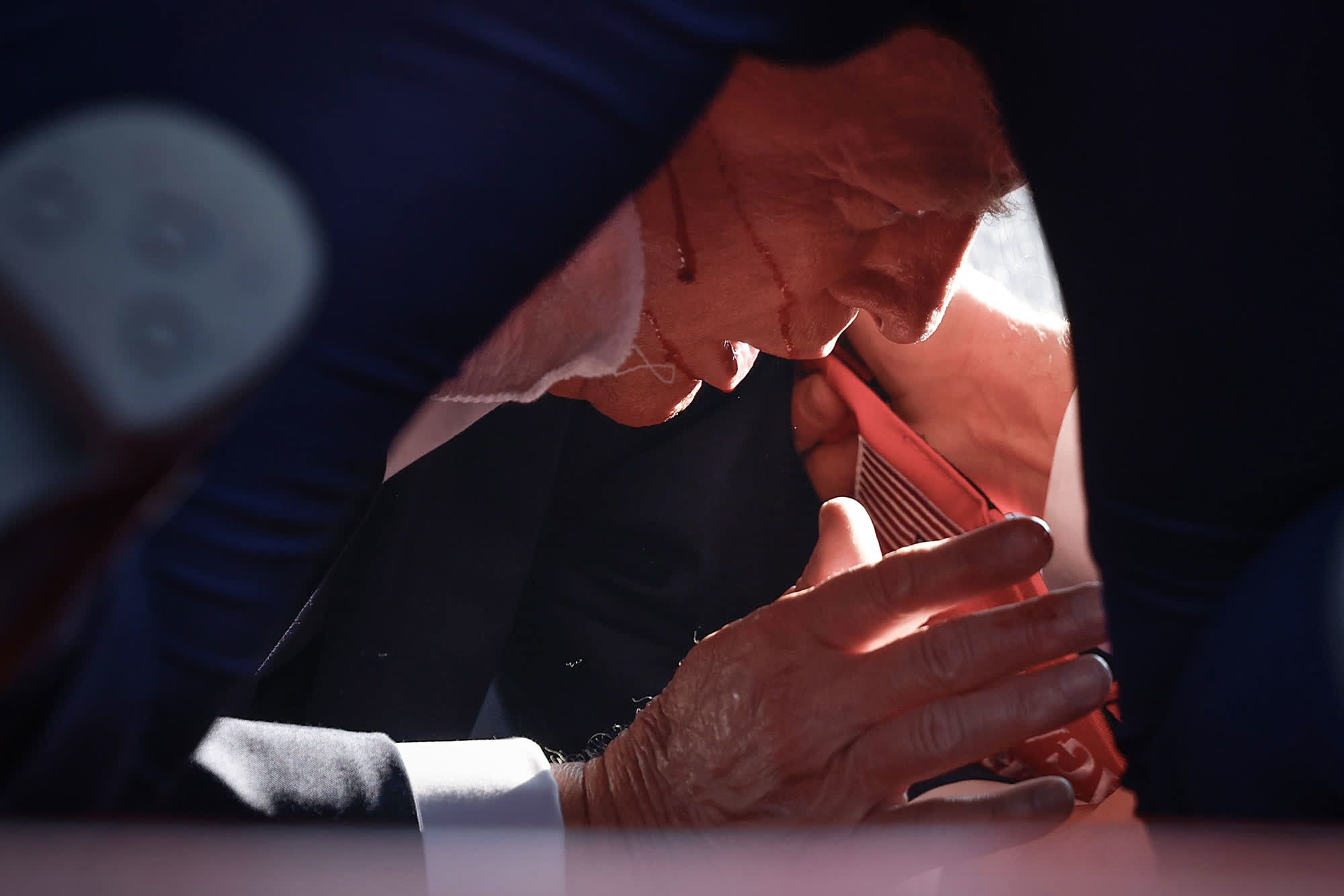 Blood can be seen on the face of former US President Donald Trump as he is covered by Secret Service agents in Butler, Pennsylvania, on Saturday, July 13. Trump had been shot in the ear.