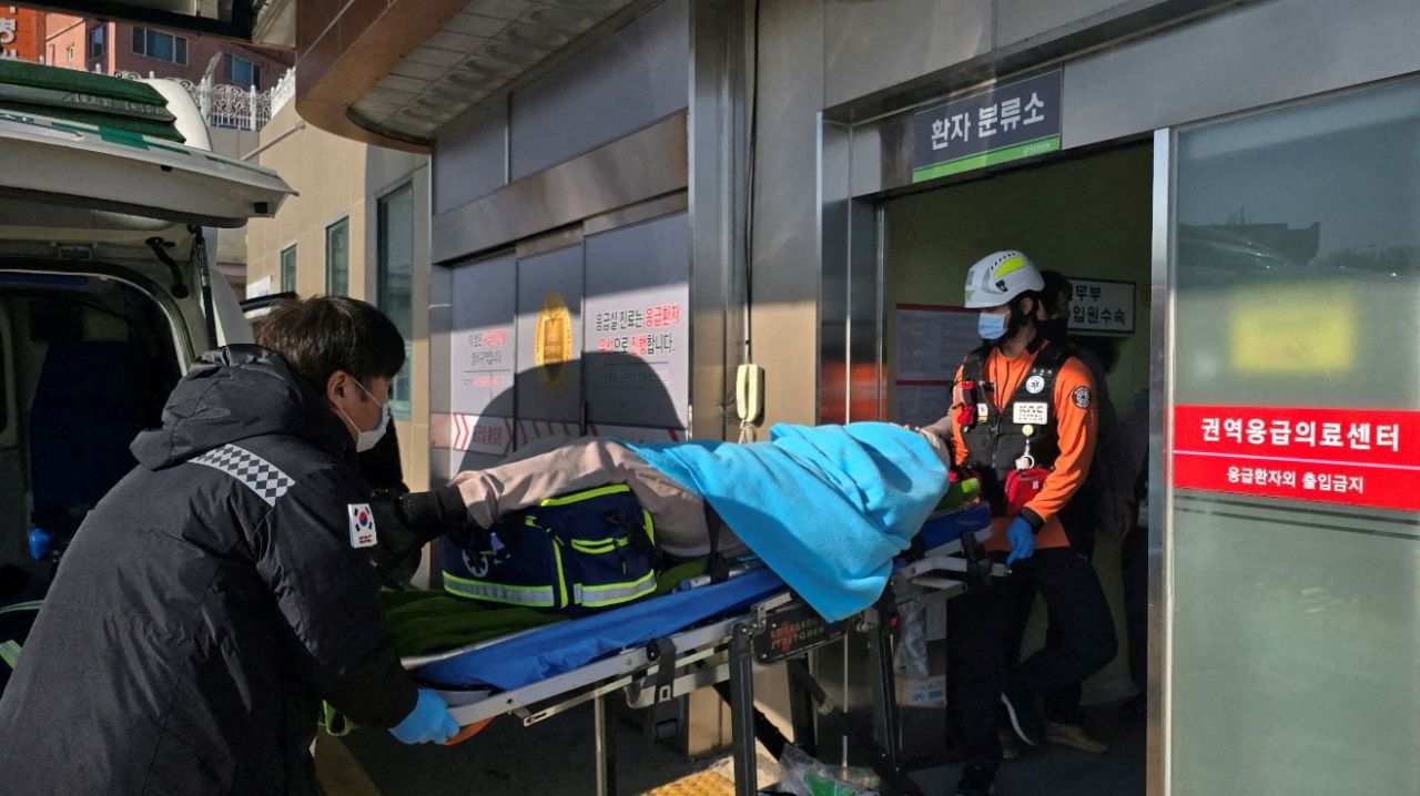 One of two passengers rescued from the aircraft is carried into a hospital in Mokpo, South Korea.