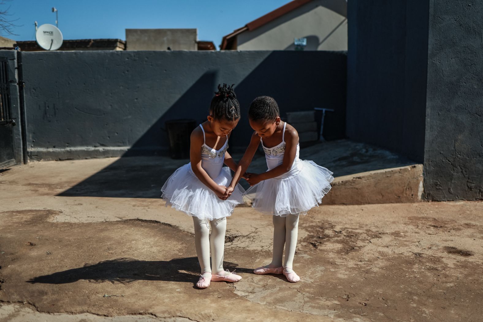 Ballet students Philasande Ngcobo, left, and Yamihle Gwababa pose for a photo outside the Mballet Dance Academy in Tembisa, South Africa, on Saturday, July 26.