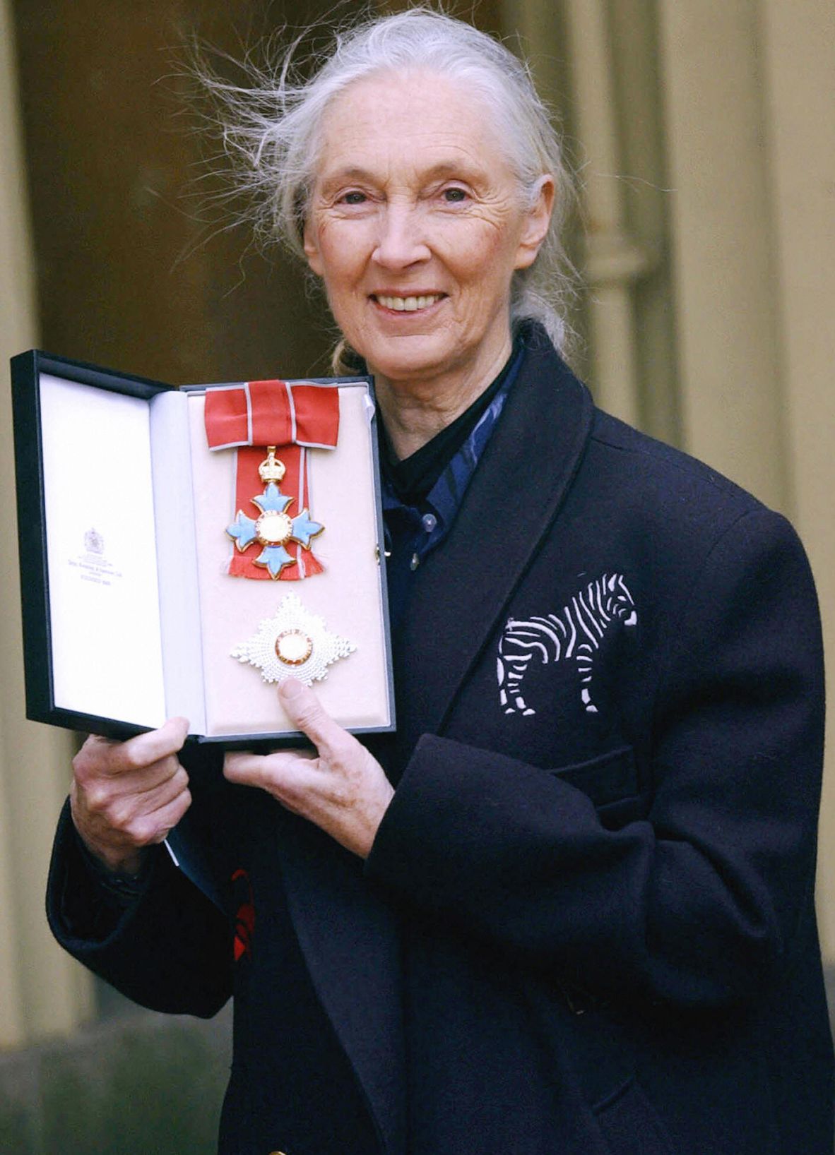 Goodall poses for pictures after she was invested as a dame of the British Empire in 2004.
